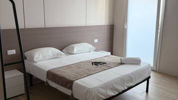 Une chambre à coucher moderne, avec un lit, une armoire et une fenêtre.
