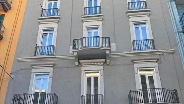 A multi-story building with a central entrance, balconies, and a sign indicating it is a hotel. - Leonida Residence (TARANTO)