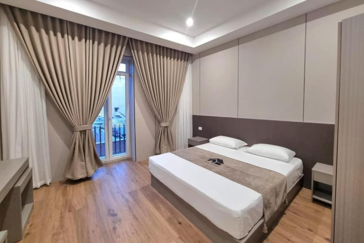 Een moderne slaapkamer met een groot bed, een nachtkastje en een kledingkast.
