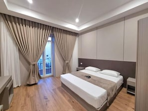 Een moderne slaapkamer met een groot bed, een nachtkastje en een kledingkast.