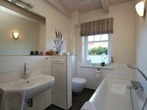 A bathroom with a sink, toilet, and bathtub. - Cockle at Susanne-fischer-weg 53 (Wyk auf Foehr)