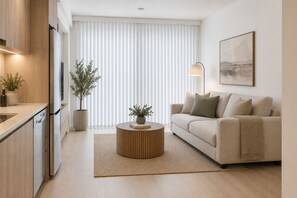 Un salon moderne avec un canapé, une table basse et un tableau accroché au mur.