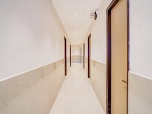 A long, narrow hallway with doors on both sides, leading to rooms.
