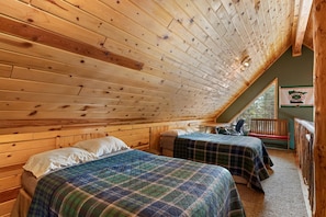 A cozy attic bedroom with two beds, a desk, and a bench. - Scenic Island Park Cabin with Private Hot Tub & ATV Access Near Yellowstone, Idaho (Island Park)