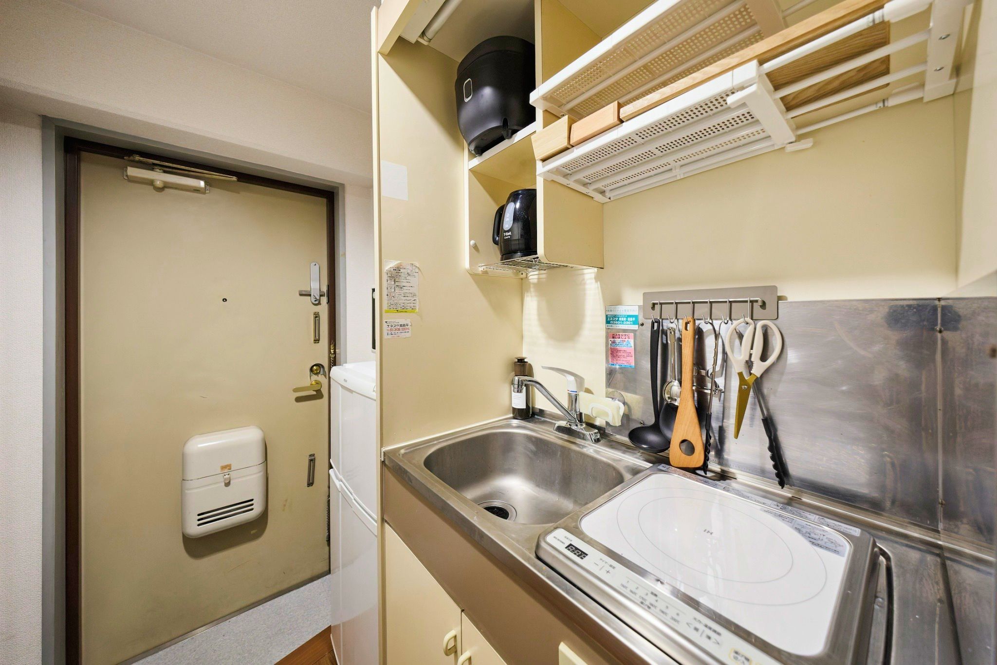 A compact kitchenette with a sink, a built-in stove, and a coffee maker.