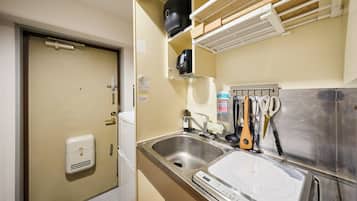A compact kitchenette with a sink, a built-in stove, and a coffee maker.