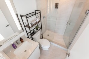 A modern bathroom with a toilet, sink, and shower. - Sunset Retreat | 2BR/2BA | CN Tower View + Parking (Mississauga)