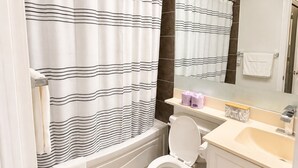 A bathroom with a bathtub, toilet, and sink. - High-Rise 3BR Oasis | Free Parking | City Views (Mississauga)