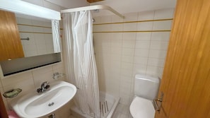 A bathroom with a white sink, a toilet, and a shower curtain.