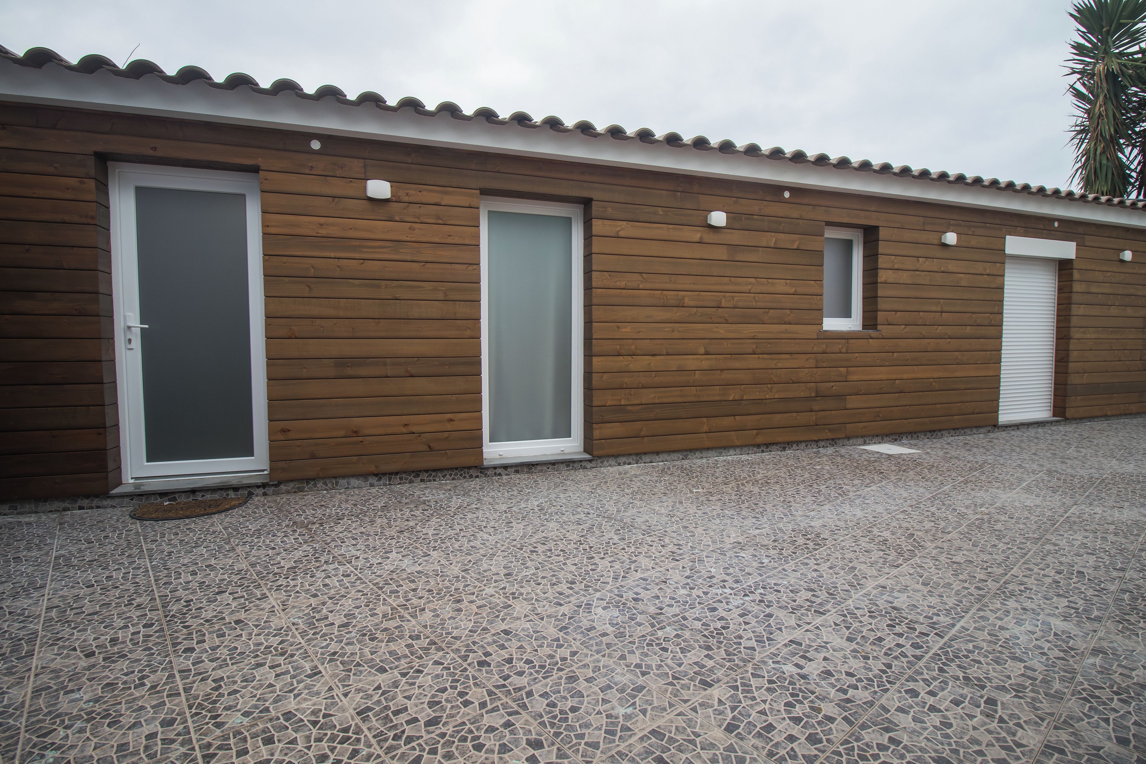 A building with three doors and a tiled floor.