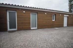 Un edificio con tres puertas y piso de baldosas.