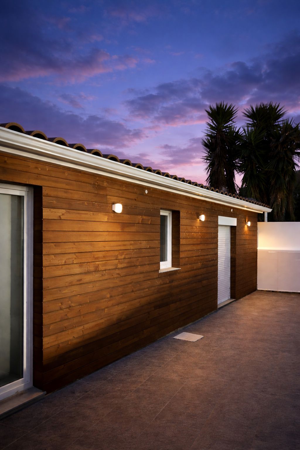 A modern building with a wooden facade, a garage door, and a small window.