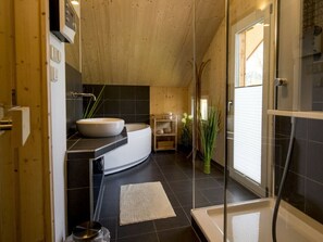 A modern bathroom with a freestanding bathtub, a large sink, and a glass-enclosed shower area. - One-bedroom Cabin (Sankt Georgen am Kreischberg)