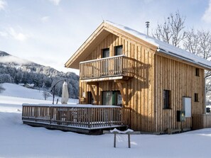 A wooden cabin with a balcony, surrounded by snow-covered landscape. - One-bedroom Cabin (Sankt Georgen am Kreischberg)