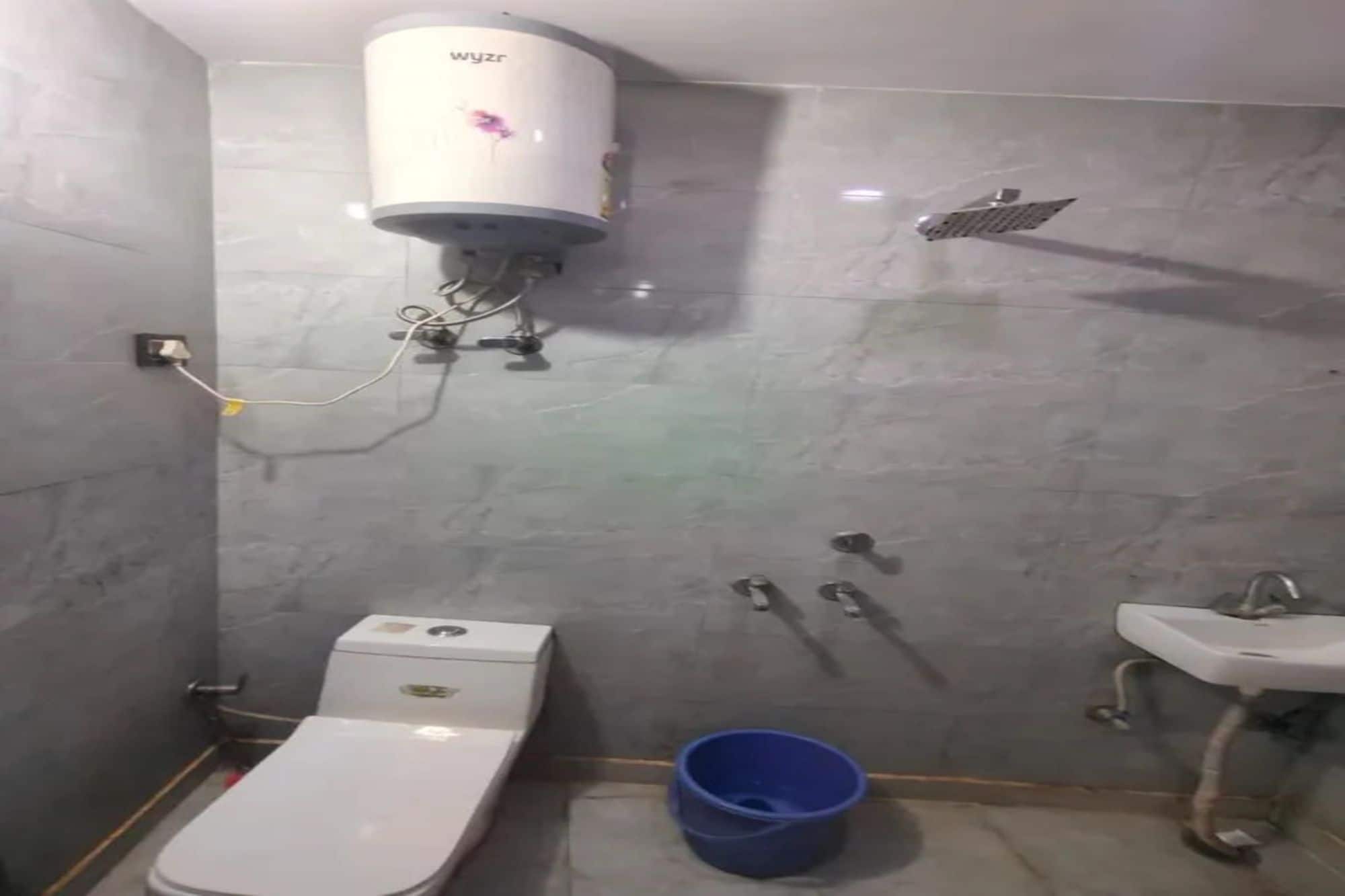 Et badeværelse med toilet, håndvask og brusebad.