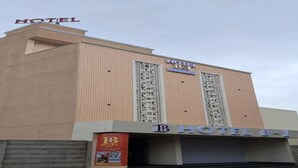 Un bâtiment d’hôtel avec une enseigne bien visible indiquant « HÔTEL B-1 » et une pancarte d’accueil en dessous.