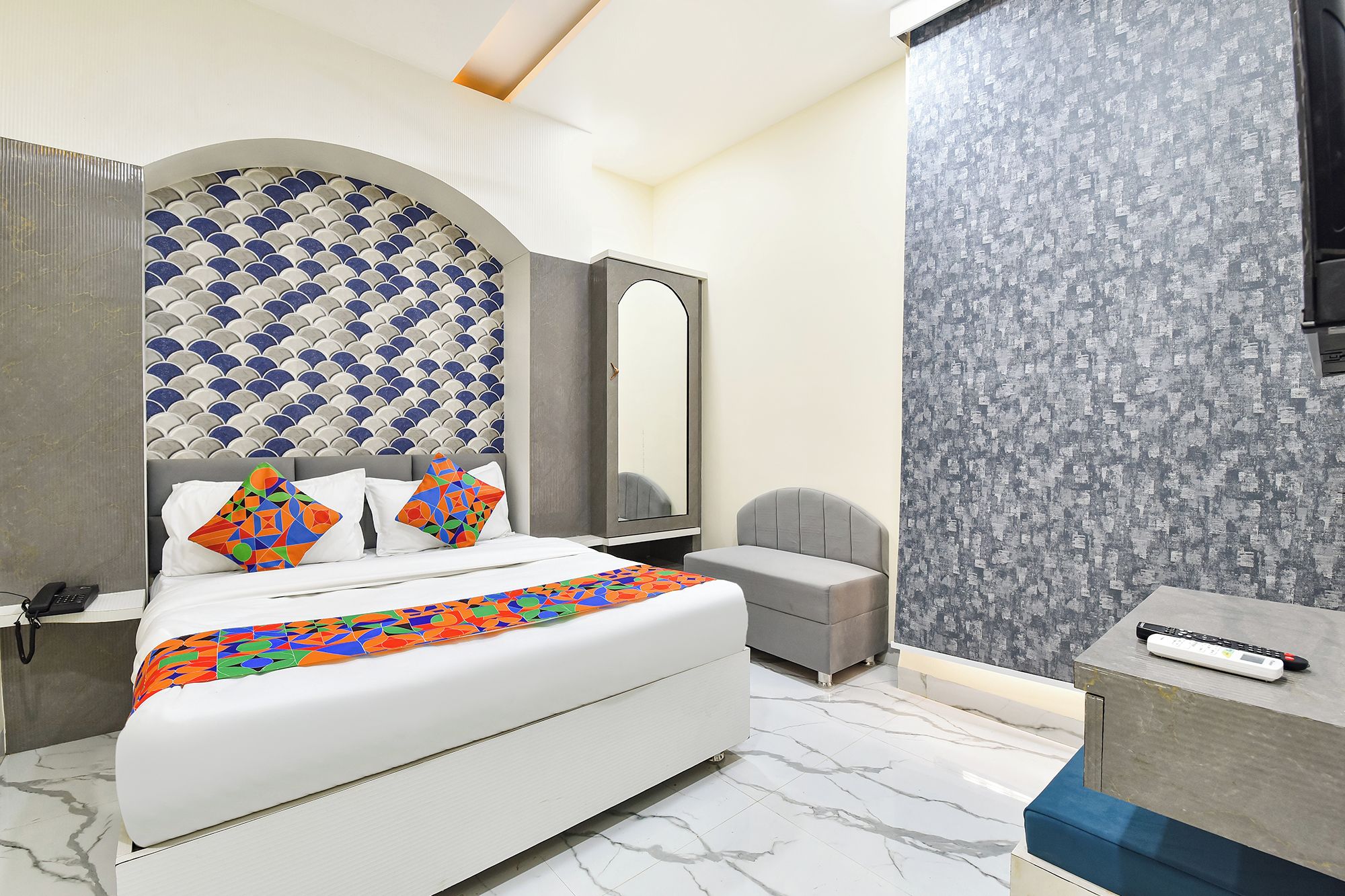 Un dormitorio moderno con cama, mesita de noche y espejo.
