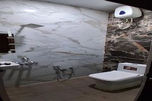 Ein Badezimmer mit Marmorwand, einer Dusche, einer Toilette und einem Handtrockner.