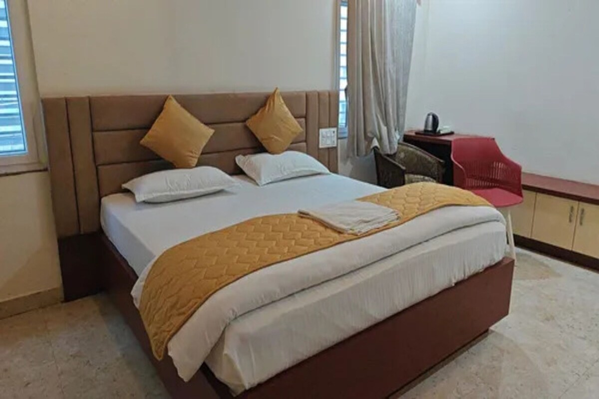 A bed with a headboard, pillows, and a blanket.