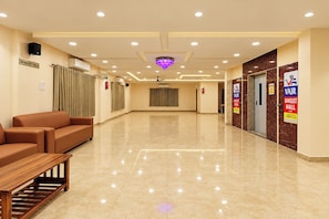 A hotel lobby with a reception desk, seating area, and a clear path to the banquet hall.