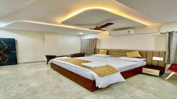 A modern hotel room with a large bed, a ceiling fan, and a flat-screen TV.