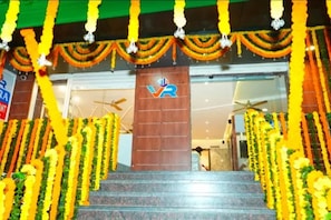 A staircase leading to a building entrance with a logo on the wall. - Fabhotel Vajra Residency (Mancherial)
