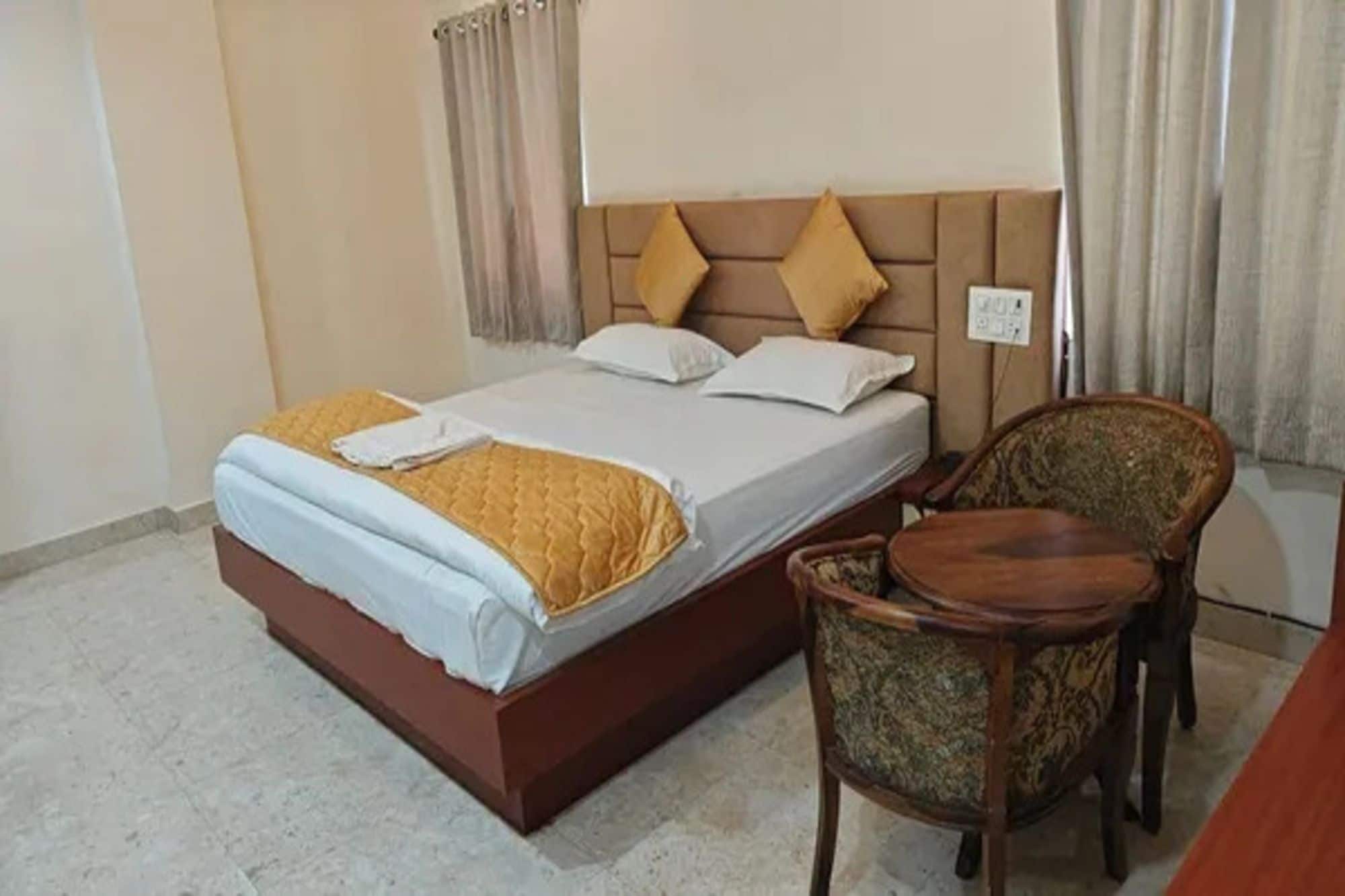 Una habitación de hotel con una cama, una silla y una mesita.