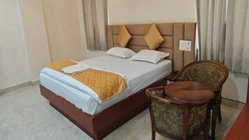Una habitación de hotel con una cama, una silla y una mesita.