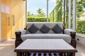 Una sala moderna con sofá, cojines y una mesa.