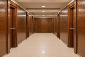 Um corredor com portas de madeira e chão de azulejos.