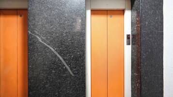 Dos puertas de ascensor con una pantalla digital sobre una de ellas.