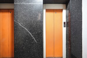 Dos puertas de ascensor con una pantalla digital sobre una de ellas.