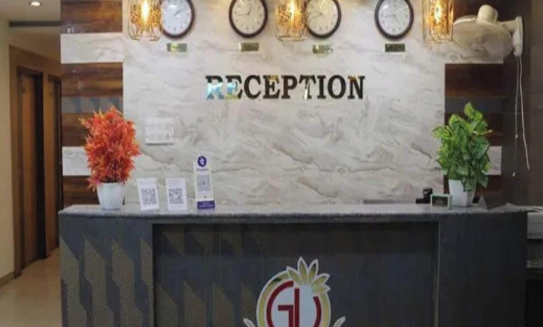 Un mostrador de recepción con encimera de mármol, relojes y un logotipo.