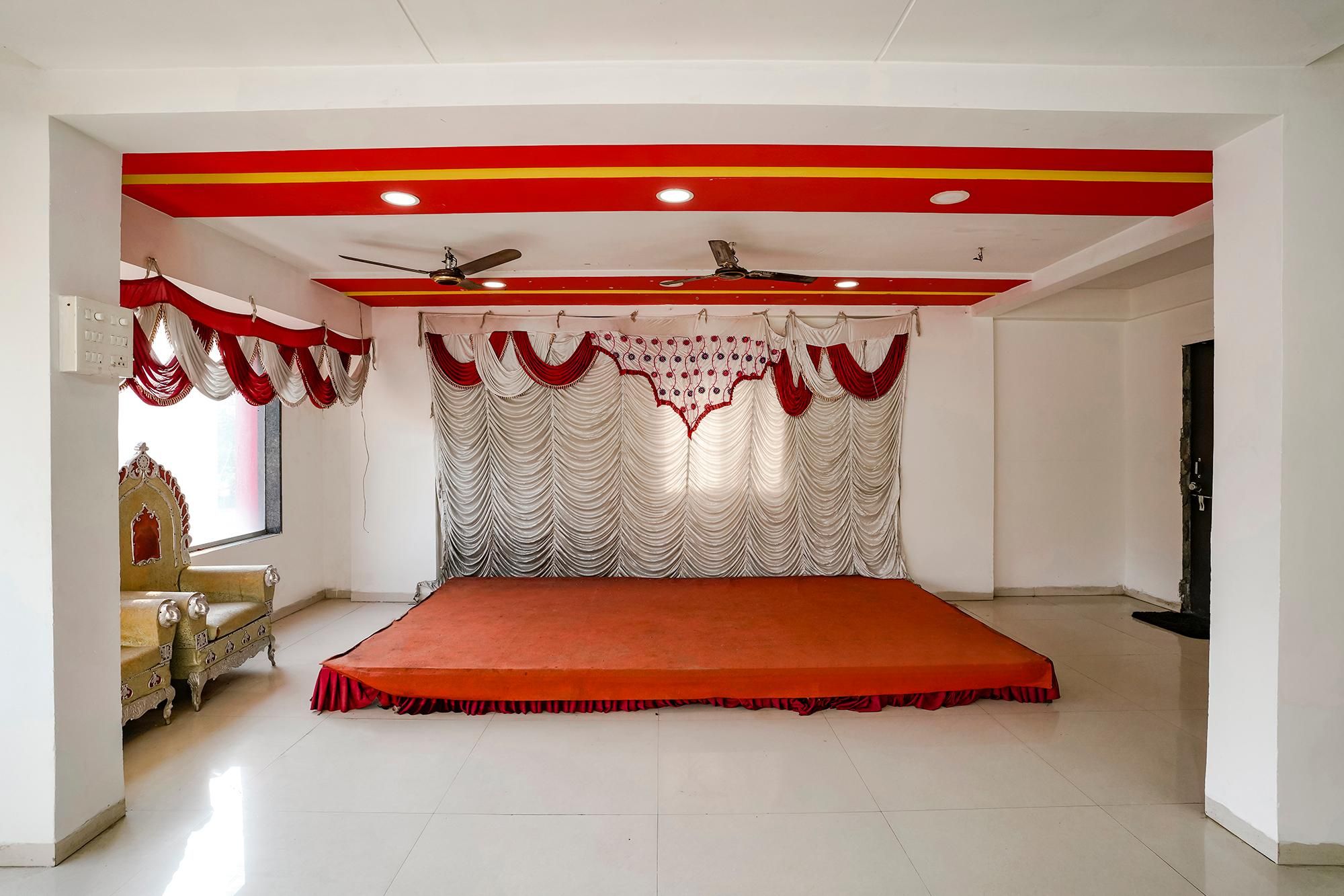 Una habitación con una cama grande, un ventilador de techo y un telón rojo y blanco.