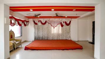 Una habitación con una cama grande, un ventilador de techo y un telón rojo y blanco.