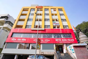 A multi-story building with a prominent yellow and red facade, featuring signs for 'Fabexpress' and 'Hotel Rama Palace'. - FabHotel Rama Palace (Nashik)
