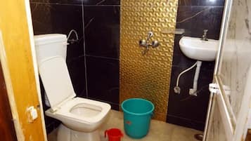 Un baño pequeño con inodoro, lavamanos y ducha.