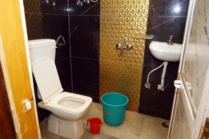 A small bathroom with a toilet, sink, and shower.