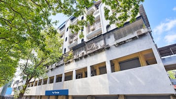 Un immeuble à plusieurs étages, sur lequel on peut lire l’inscription « Via », indiquant qu’un commerce ou un service est situé au rez-de-chaussée.