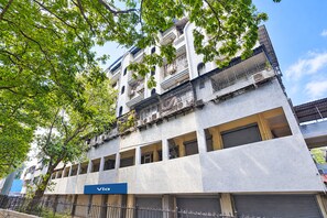 Un edificio de varios pisos con un letrero que dice 'Via', indicando un negocio o servicio en la planta baja.