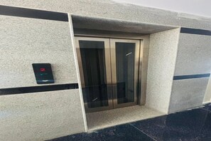An elevator with a digital control panel on the wall. - Fabhotel Royal Elite Luxury (Hyderabad)