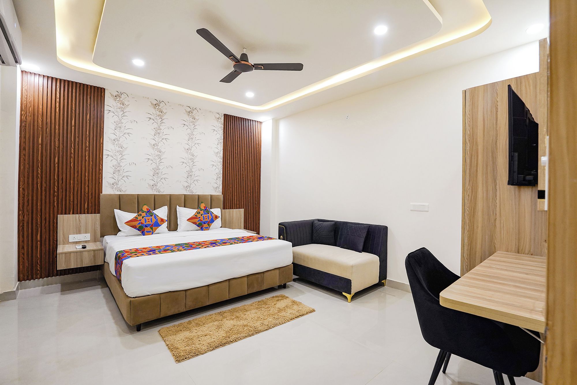 Un dormitorio moderno con cama, mesita de noche y ventilador de techo.