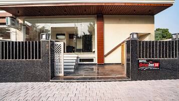 Una entrada de hotel moderna con puerta de vidrio, escalera de madera y un letrero que dice Hotel Drive Inn 32.