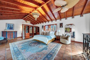 A spacious bedroom with a large bed, a sitting area, and a view of the outdoors. - Villa Brisas in Coral Gables area (Miami)