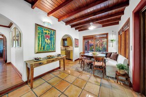 A spacious living area with a wooden ceiling, a dining table, and a sofa. - Villa Brisas in Coral Gables area (Miami)