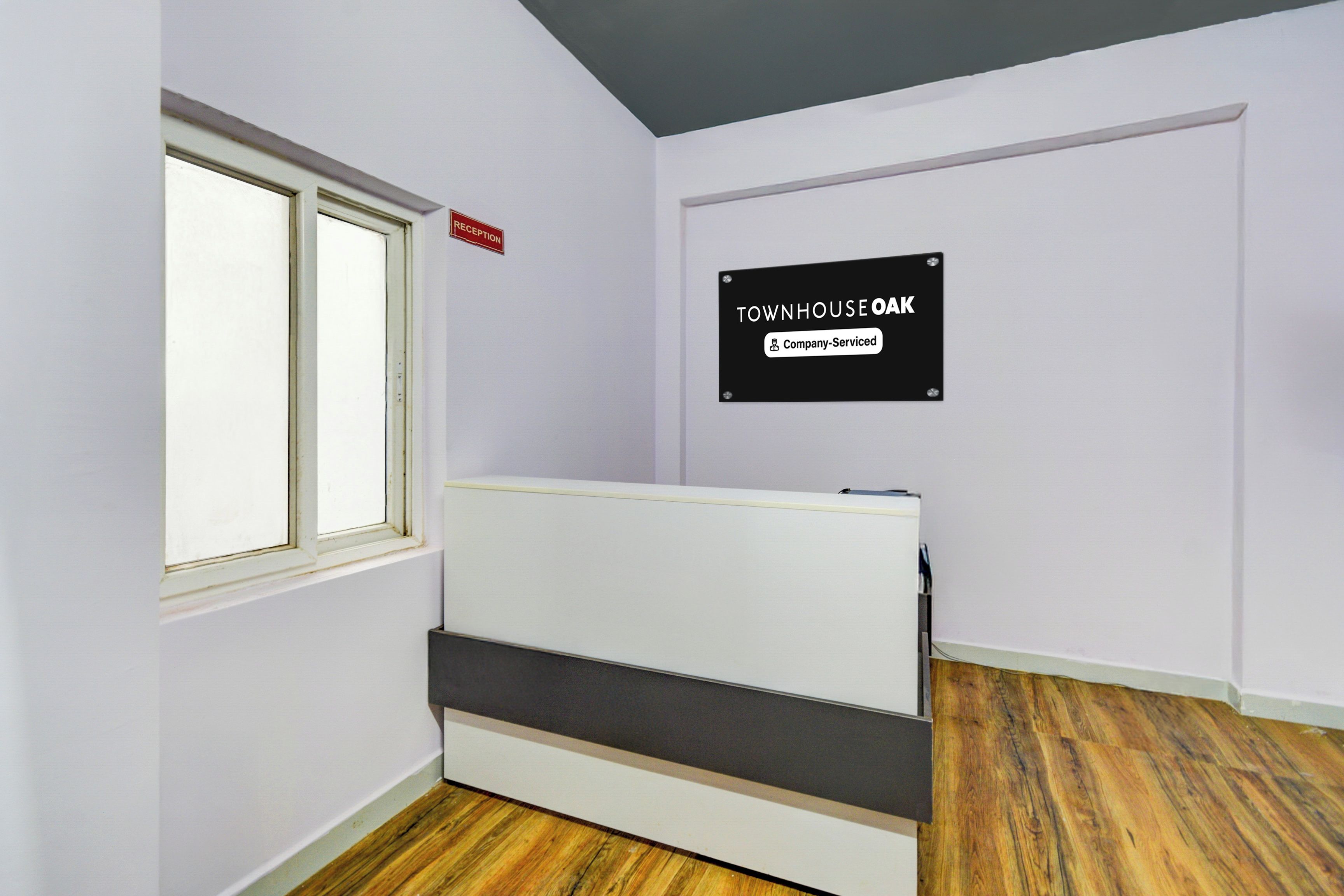 Una habitación con una cama, un letrero de recepción y un aviso que indica servicio de la empresa.
