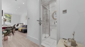 Une salle de bain moderne avec une douche à parois de verre, un lavabo blanc et un miroir.
