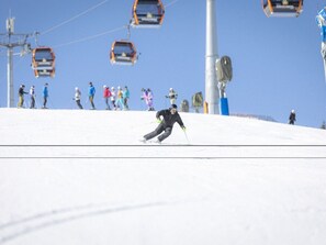 A ski slope with skiers and a chairlift in the background. - One-bedroom Cabin (Sankt Georgen am Kreischberg)