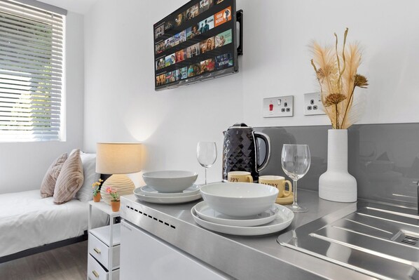 A modern kitchen with a built-in oven, a coffee maker, and a kettle on the counter.