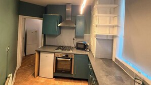 Cocina compacta con horno integrado, microondas y estufa a gas.